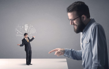 Young businessman fighting with miniature businessman