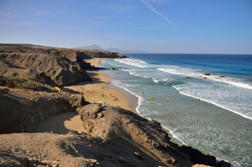 seascape of the beach and ocean with surfers
