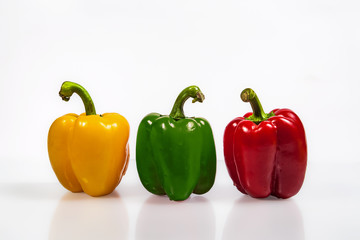 yellow, red and green peppers on a white background