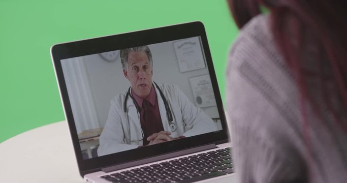 Woman talking to senior doctor on her laptop on green screen. On green screen to be keyed or composited. 