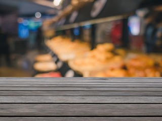Empty wood table top on blur bakery shop or cafe restaurant with abstract bokeh background, Perspective dark brown wood table over blur in coffee shop background.