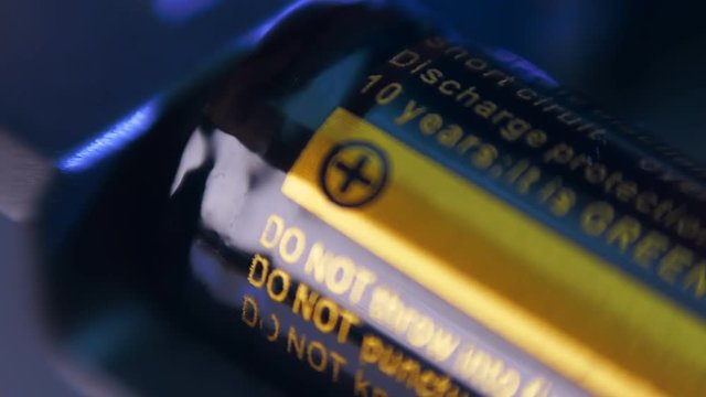 Insert new batteries into the remote control. The plus side of the battery is close-up. Macro. Closeup. Shallow depth of field
