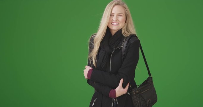 Young white woman smiles at the camera on green screen. On green screen to be keyed or composited.