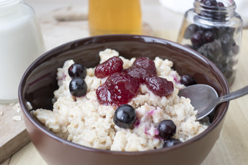 Delicious oatmeal porridge with berry and almonds for breakfast.