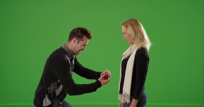 Millennial boyfriend proposes to girlfriend on green screen. On green screen to be keyed or composited. 