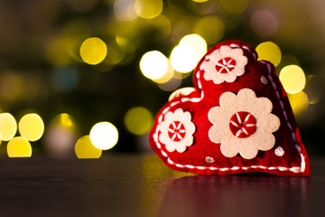 Christmas decoration heart with Christmas tree lights in background
