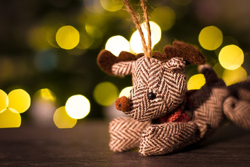 Christmas reindeer ornament with Christmas tree lights in background