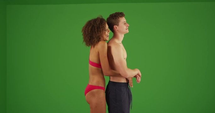 Profile view of couple standing on beach embracing on green screen. On green screen to be keyed or composited. 