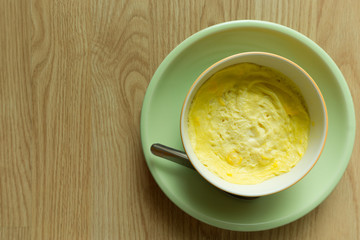 Steamed eggs in a bowl on wooden floor