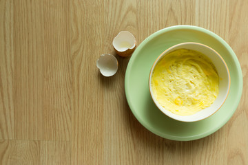 Steamed eggs in a bowl on wooden floor