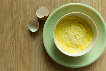 Steamed eggs in a bowl on wooden floor