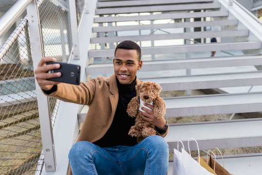 Stylish man taking selfie with toy