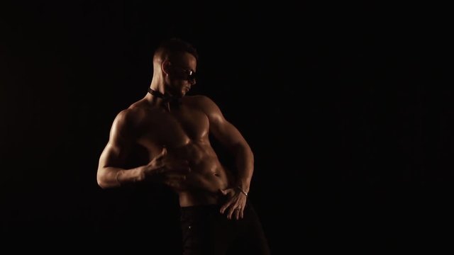 Sexy man dancing on black background