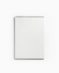 Blank notepad for sketching on white paper background. Album with spiral. Free space. Flat lay.