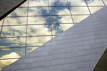 Perspective view of the modern building facade with clouds reflections on the windows