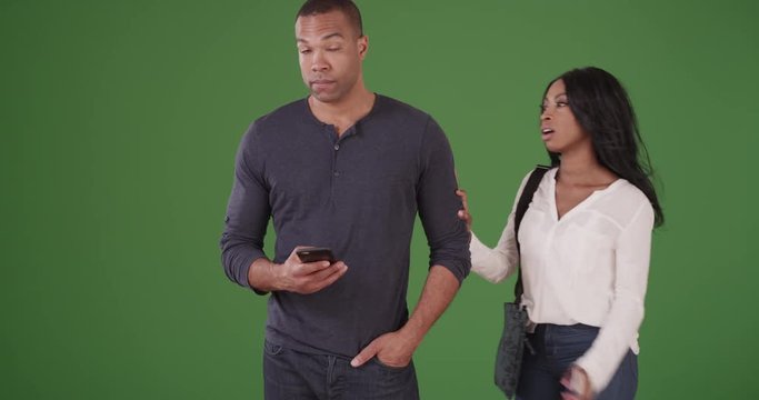Black couple meet and walk off holding hands on green screen. On green screen to be keyed or composited. 