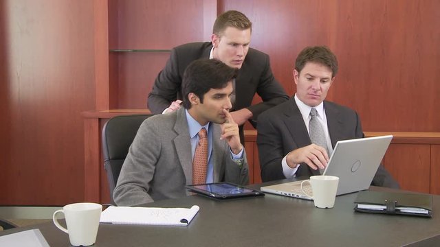 Three businessmen working at table