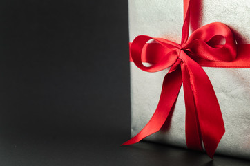 Gift in silver packaging with red ribbon and greetings with Valentine's day.