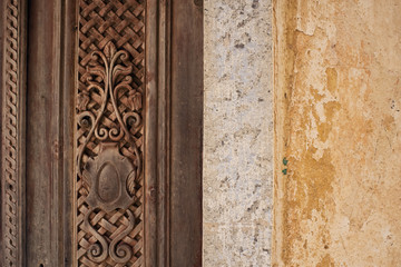 details of a carved door and a decrepit wall in the village of olympos