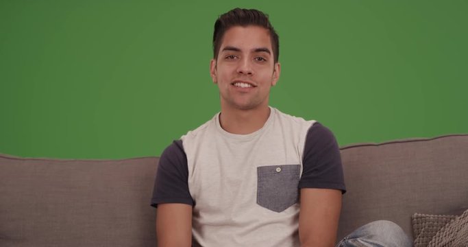 Young millennial Latino man talking to camera. on green screen. On green screen to be keyed or composited. 