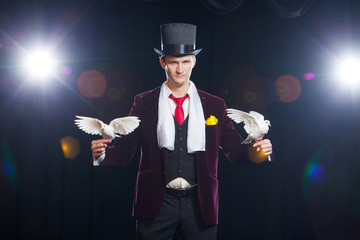 The magician with a two flying white Doves. on a black background