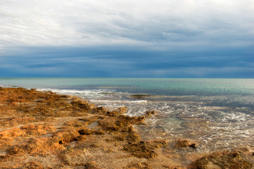 The calm sea in a very cloudy sunset