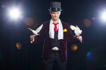 The magician with a two flying white Doves. on a black background