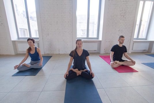 yoga class training, morning exercises in white interior 