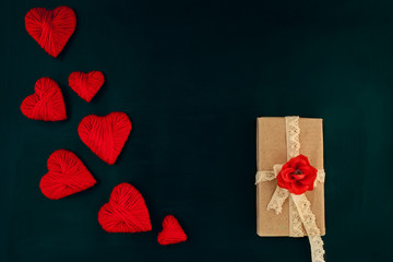 valentines day, red hearts on a dark background with a gift, space for text