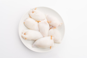 raw calamari on plate isolated on white