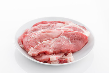 lean pork steaks on plate isolated on white