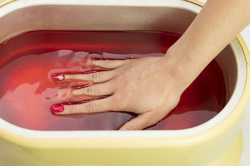 Process paraffin treatment of female hands in beauty salon