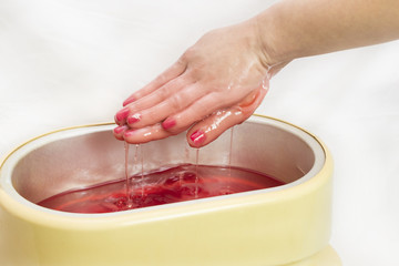 Process paraffin treatment of female hands in beauty salon