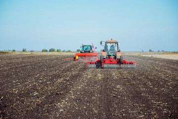 Obraz premium Tractor with a roller on the field at spring