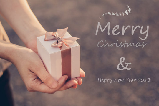 Time gifts - gift box in hand for Christmas with MERRY CHRISTMAS and HAPPY NEW YEAR 2018 /soft focus picture / Vintage concept