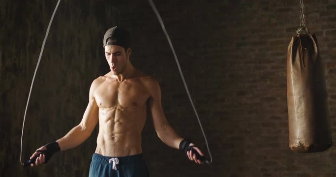  A muscular and sweaty man is training at the gym by lifting the gym weights to strengthen his muscles. Concept of: workout, workout, power, supplements, fitness