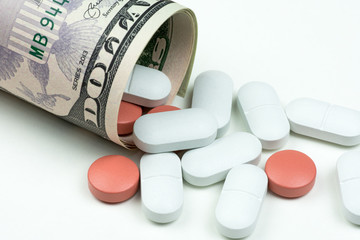 Medicines, capsules and pills on dollar bills