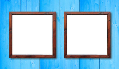 Two empty wooden frames on the wall. White inside and light blue background, space for text.