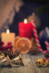 Jingle bells on wooden rustic background of Burning candles and Christmas decoration