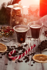 Black coffee in glass cups with christmas decoration and candies. Morning toned