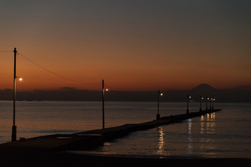Mellow sunset at Haraoka-kaigan beach, Chiba-Japan. Charming wooden pier melting into the water with silhouetting Mt. Fuji.
