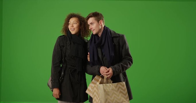 Charming couple shopping at night on green screen. On green screen to be keyed or composited. 