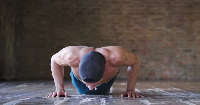  A muscular and sweaty man is training at the gym by lifting the gym weights to strengthen his muscles. Concept of: workout, workout, power, supplements, fitness