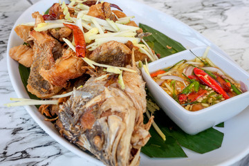 Close up of deep Fried Snapper topped with mango sliced