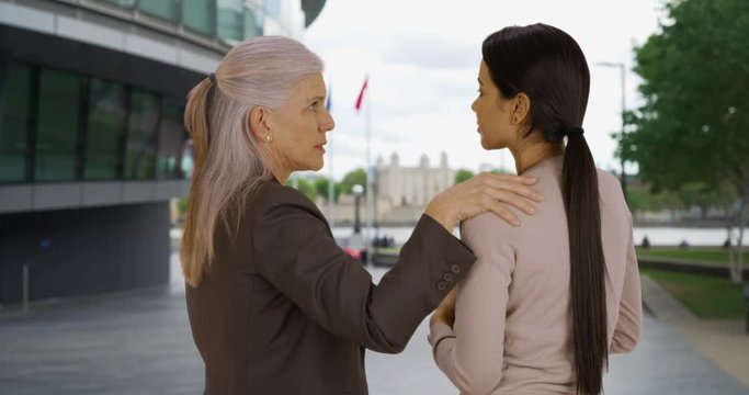 Compassionate Senior Woman Executive Giving Young Businesswoman Advice