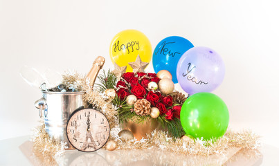 New Year's decoration with a decorative clock, balloons, bottle of sparkling champagne and beautiful flowers composition