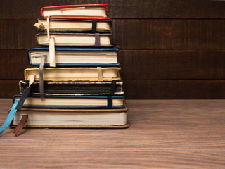 A stack of notebooks on a wooden table