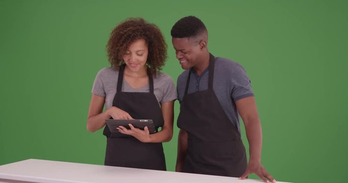 Black man and woman plan their recipe on their tablet on green screen. On green screen to be keyed or composited. 