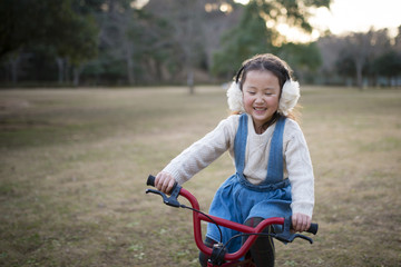 Obraz premium 赤い自転車で遊ぶ女の子