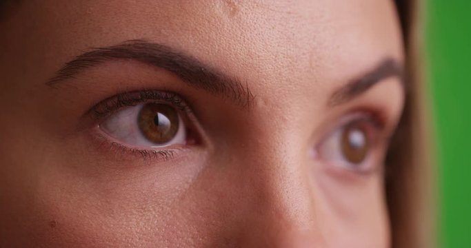 Female millennial's eyes blinking on white background on green screen. On green screen to be keyed or composited.